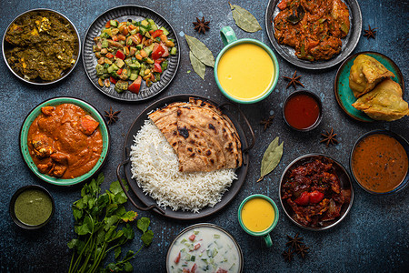 马萨拉蒂摄影照片_从上面的质朴混凝土桌上享用各种印度民族美食自助餐