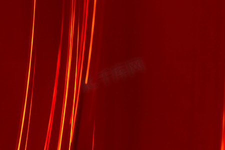 红色光线背景摄影照片_勃艮第背景上明亮的红线光线。