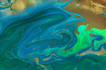 流动蓝色和绿色波浪上的金点油漆抽象背景