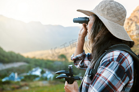 山地风景摄影照片_使用双筒望远镜、登山杖和助行器在偏远的风景中徒步旅行、探索和山地冒险。