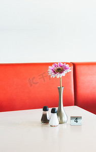 咖啡厅复制空间的室内桌子设置，花盆、盐和胡椒瓶和金属数字标记