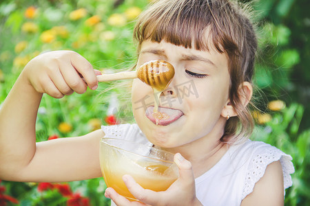 孩子秋天摄影照片_孩子吃蜂蜜。