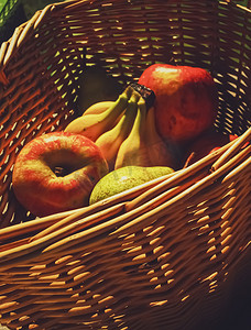 柳条篮里的有机苹果、梨和香蕉