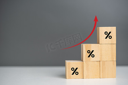 木制立方体通货膨胀和箭头红色，背景和复制空间上带有木立方体百分比符号。商业财务概念。