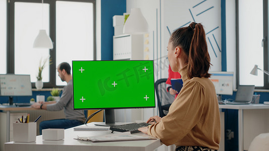 同事们在电脑显示屏上与绿屏一起工作