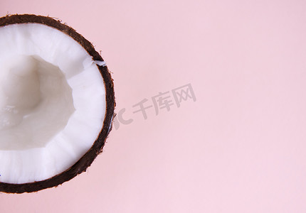 一半甜甜可口的生素食椰子，用粉红色隔离，带有广告复制空间。