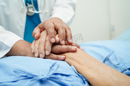 古代医者和摄影照片_医生手牵亚洲老年女病人的手，在医院提供帮助和护理。
