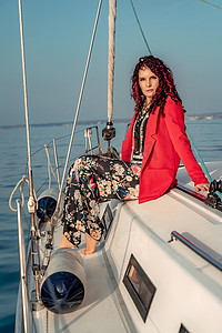 在阳光明媚的夏日，一位女士坐在游艇的船头，微风吹拂着她的头发，背景是美丽的大海