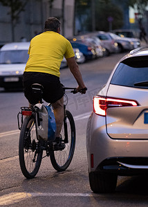 骑自行车的人在光线昏暗的道路上超车。