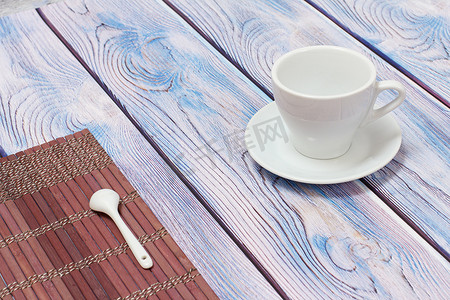 有茶碟和竹餐巾的瓷杯在木背景。