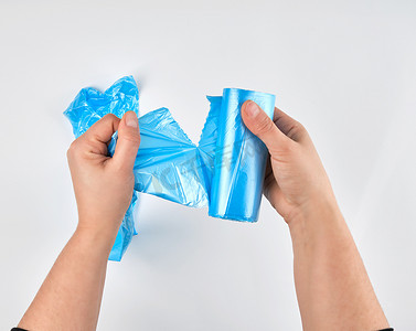 女手从 ro 上撕下一个透明的蓝色袋子作为垃圾箱