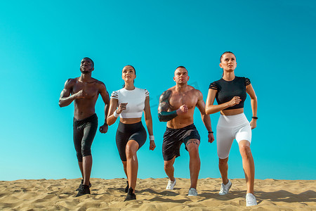 奔跑的运动员摄影照片_一群年轻的男女运动员，适合在天空背景下奔跑的运动员。