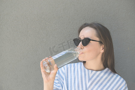 女人拿着装有清水的玻璃瓶