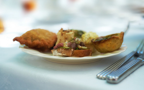 在下午茶活动或高级餐厅的瓷盘和菜肴上供应美味小吃的特写。