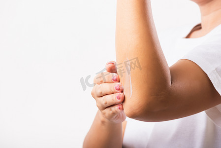 女人在肘部涂抹乳液霜