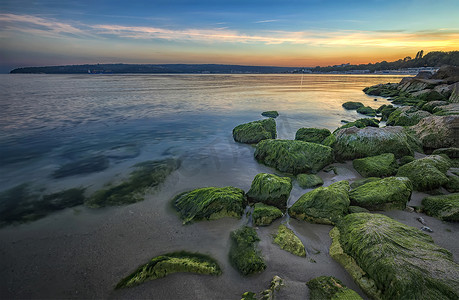 美丽的海岩石海岸，石头上有绿色的青苔。