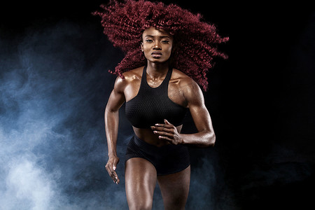 一位强壮的女短跑运动员，在日出时穿着运动服、健身和运动动机概念跑步，并带有复制空间。