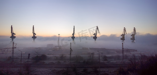经济学摄影照片_港口起重机笼罩在晨雾中。