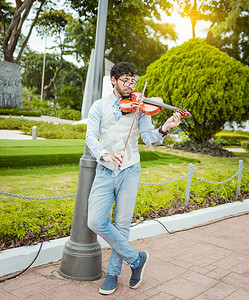 拉小提琴摄影照片_在街上拉小提琴的男人的画像。