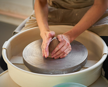 女人在轮子上制作陶瓷陶器，创造陶瓷器皿。