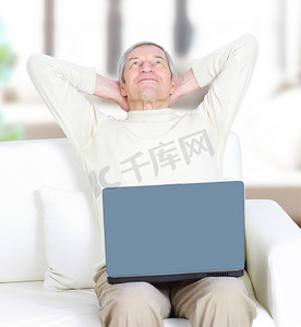 成年男性在家休息拿笔记本电脑。
