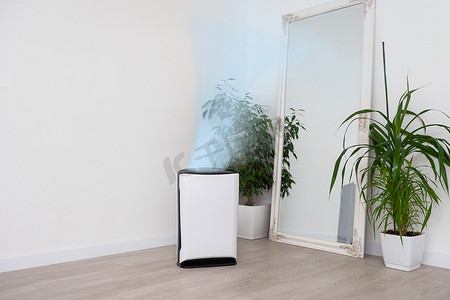 舒适白色客厅的空气净化器，用于过滤和清洁去除家中的灰尘 PM2.5 HEPA 和病毒，以获得新鲜空气和健康的健康生活，空气污染概念
