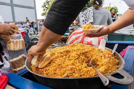 肠粉矢量摄影照片_尼加拉瓜街头食品销售，男子供应巴伦西亚米饭和面包