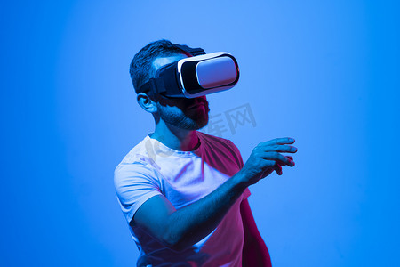 年轻人特写肖像戴着 VR 耳机，在玩游戏时与元宇宙中的朋友交谈。