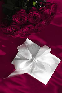 豪华假日丝绸礼盒和葡萄酒背景玫瑰花束、浪漫惊喜和鲜花作为生日或情人节礼物