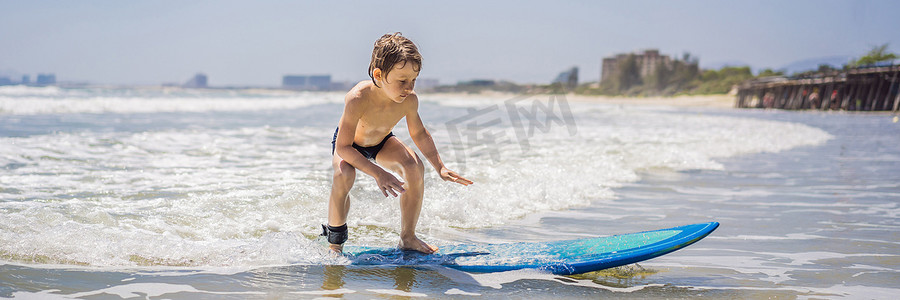 banner蓝色摄影照片_学习在大海或海洋中冲浪的健康小男孩 BANNER，LONG FORMAT