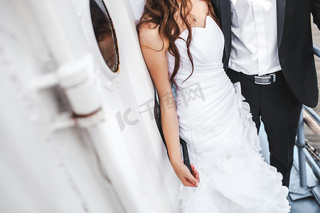 婚礼新娘和新郎在船的甲板上，时尚的情侣。
