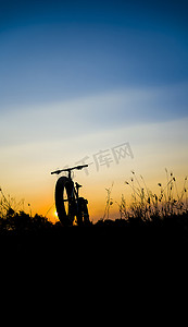 美丽的夕阳天空和山地自行车剪影，剪影胖自行车