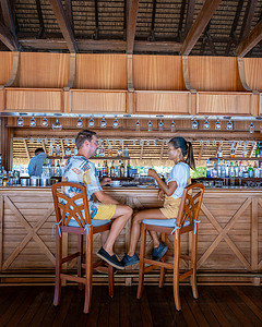 一对男女度假期间在热带岛屿的酒吧喝一杯
