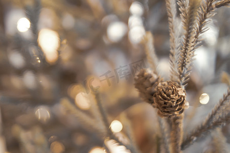 金色雪花图案摄影照片_金色圣诞节背景的去焦点灯与装饰树。