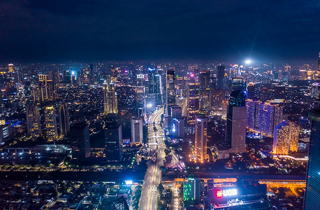 印度尼西亚雅加达现代市中心摩天大楼和多车道高速公路交通的空中夜景 2021年夜间高层建筑的城市中心