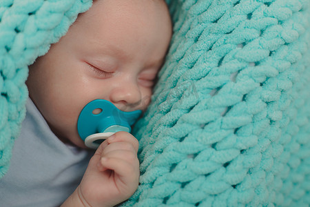 床上睡觉的婴儿摄影照片_婴儿正在婴儿床上睡觉。