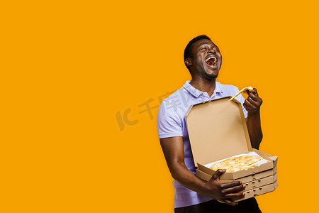 有趣的黑色快递员笑着拿着一块比萨饼和 4 个比萨饼盒。