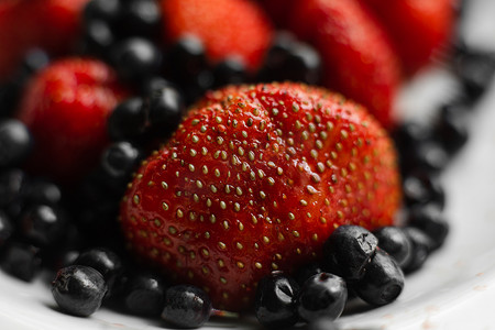 拼多多拼团摄影照片_许多多汁的新鲜成熟红草莓浆果与黑莓隔离在白色背景
