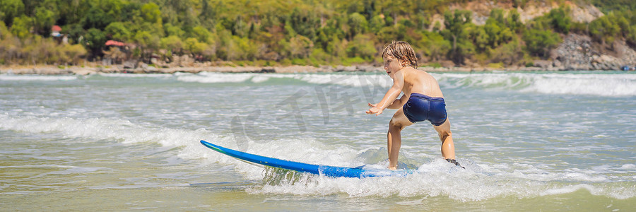 banner蓝色摄影照片_学习在大海或海洋中冲浪的健康小男孩 BANNER，LONG FORMAT