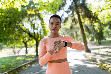 非裔美国女运动员训练前选择手镯上的健身计划