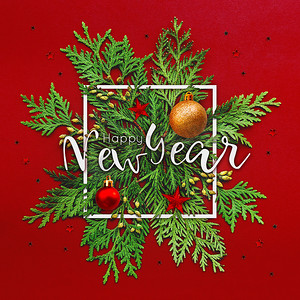 圣诞节背景与崖柏树枝和白色方框中的文字新年快乐。