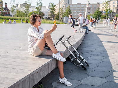 俄罗斯莫斯科 — 2021年6月13日。女人坐在公园的木制露天舞台上。