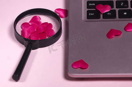 红心火龙果树摄影照片_电脑键盘上的红心，带手柄的放大镜。
