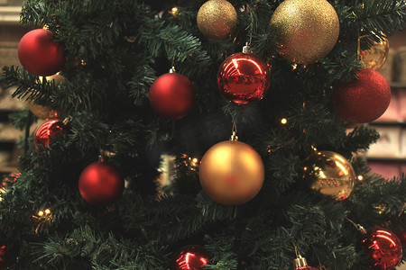 圣诞树木摄影照片_圣诞商店陈列着红色和金色的圣诞饰品