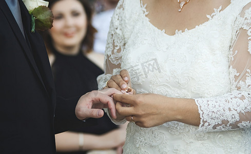 一对夫妇在婚礼上结婚 — 新娘将金戒指戴在新郎的手指上