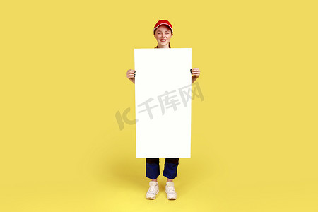 纸质海报背景摄影照片_女工程师站着，拿着一张纸质标语牌，上面有空白的文字空间。