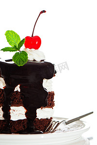 小蛋糕薄荷摄影照片_一个小巧克力蛋糕，有 2 层白奶油、樱桃和薄荷