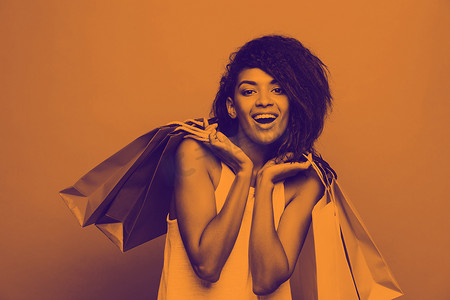 购物概念-肖像年轻美丽迷人的非洲女人微笑和快乐的头像彩色购物袋。