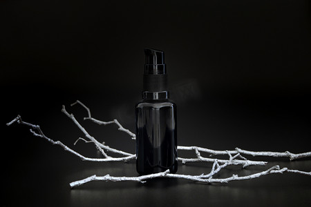 黑色无品牌美容精华液，带有银树枝。