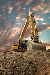 日落时建筑工地土方工程中的履带式挖掘机